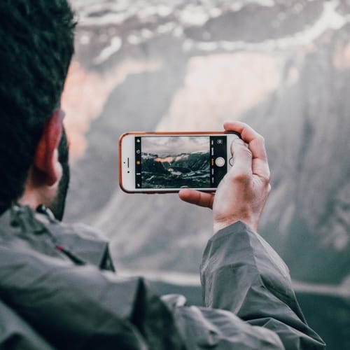 guy take a picture of a lake with his phone