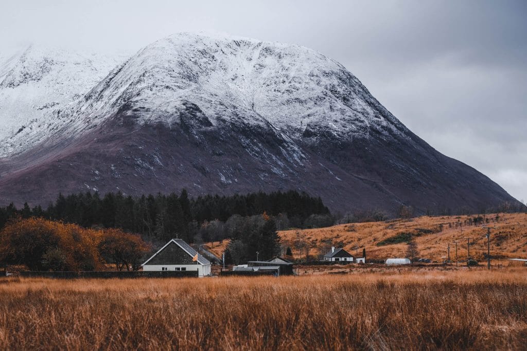 white house with snow mountain on the background scotland